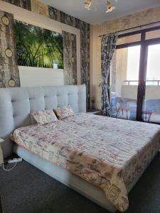 布尔加斯Lazuren Bryag Lux suite的一间卧室设有一张大床和大窗户