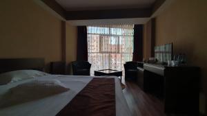 德罗贝塔-塞维林堡Guest House Bulevard的一间卧室配有一张床、一张书桌和一个窗户。