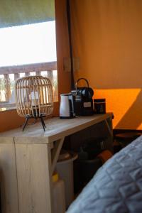 吕洛Safaritent Lodge 2 plus的一张桌子、咖啡壶和一个篮子