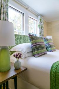 卡姆登怀特豪尔酒店的一张带枕头的床和一张桌子上的台灯