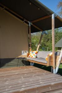 吕洛Safaritent Lodge 5的木甲板上一张天蓬下的床铺