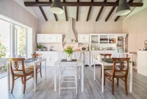 克雷米亚B&B La Dolce Casa Lago di Como的厨房配有白色橱柜和桌椅