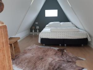 阿尔克马尔BenB Humblebee的一间卧室配有一张床和毛皮地毯