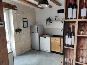 LigueilMaison de charme的厨房配有冰箱和带葡萄酒瓶的吧台