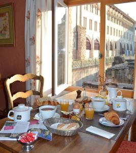 克卢尼勃艮第酒店的一张桌子,上面有早餐食品,窗户