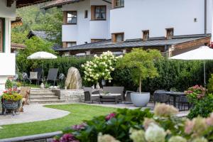 迈尔霍芬加尼克瑙尔别墅酒店的一个带桌椅和遮阳伞的花园