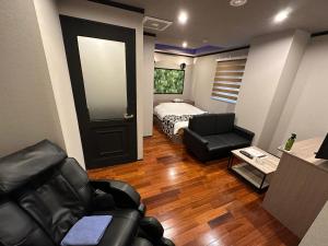 横滨grandir ｸﾞﾗﾝﾃﾞｨｰﾙ-Adult Only-的客厅配有床、沙发和椅子