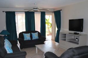 乌旺戈海滩Laguna la Crete 66的客厅配有2把椅子和平面电视
