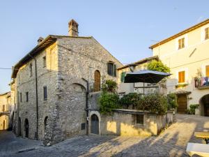 StronconeCasa Della Torre In Borgo Medievale的街道上一座带遮阳伞的古老石头建筑
