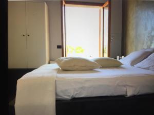 圣维托罗卡波Villa Il Cappero的一张带两个枕头的白色床和窗户