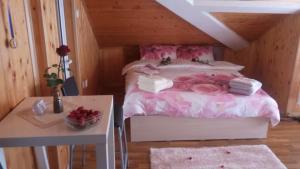斯利文Green Loft Apartment-Rose的一间卧室配有一张带粉色床单和一张桌子的床。