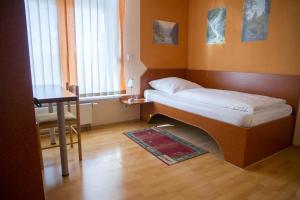 哈尔伯格摩斯古腾堡嘉尼豪斯酒店的小房间设有一张床和一张桌子