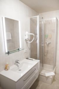 哈尔伯格摩斯古腾堡嘉尼豪斯酒店的白色的浴室设有水槽和淋浴。