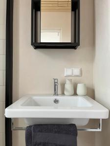 维尔扬迪Castle Hills Residence的浴室设有白色水槽和镜子