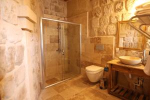 于尔居普Vita Cave Suites的带淋浴、卫生间和盥洗盆的浴室