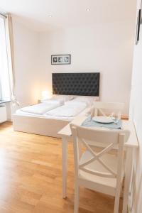 美因河畔法兰克福Charming Apartments Frankfurt City的卧室配有1张床、1张桌子和1把椅子