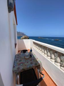 圣克鲁斯-德特内里费Room in Lodge - Beautiful Sunsets from the Balcony El Roque的俯瞰大海的阳台配有桌椅