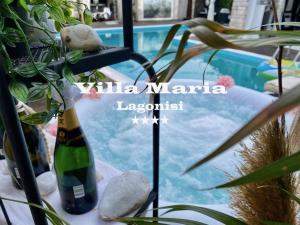 卡利维亚索里库Villa Maria Lagonissi - Private first floor Villa的游泳池畔的一瓶香槟