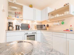 萨斯尼茨Appartementhaus Sonnenbad - Luxuspenthouse App. 11的厨房配有白色橱柜和大理石台面