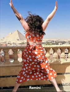 开罗Crowne Pyramids view inn的穿波卡圆点的女人跳过栅栏