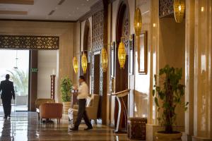 沙姆沙伊赫Sunrise Arabian Beach Resort的走在酒店大堂走廊的人