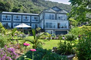 维德尼斯Serenity Ocean Lodge的蓝色的建筑,前面有一个花园