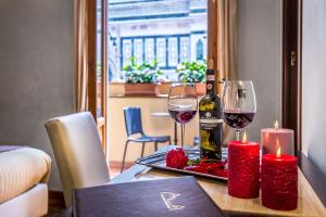 佛罗伦萨佛罗伦萨大教堂酒店的一张桌子,上面放着一瓶葡萄酒和两杯酒
