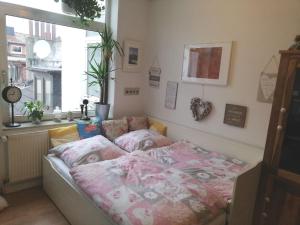 不莱梅Penthousewohnung 126 qm Bremen Innenstadt+ Dachterrasse的一间卧室配有一张带粉色床单的床和一扇窗户。