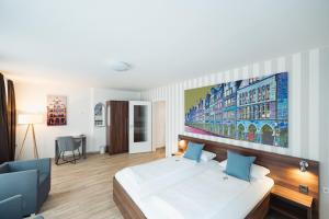 明斯特Hotel Busche am Dom的卧室配有白色的床和墙上的大画作
