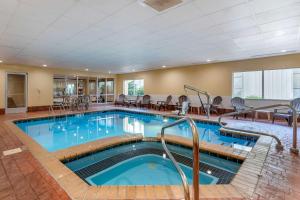 弗洛伦斯Comfort Suites Florence Shoals Area的一座配有桌椅的酒店游泳池