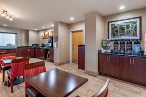 弗洛伦斯Comfort Suites Florence Shoals Area的一间带桌椅的餐厅和酒吧