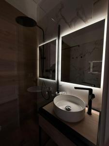 罗镇Rhospitality - Visconti Affittacamere的一间带水槽和大镜子的浴室