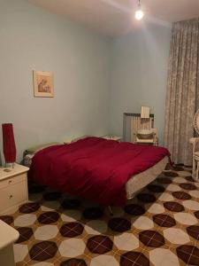 普蒂尼亚诺De Nicolò Home的卧室配有红色的床,铺有瓷砖地板。