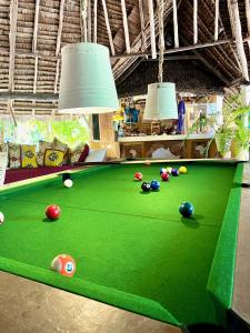 瓦塔穆Rock and Sea Resort的一张绿色的台球桌,上面有球