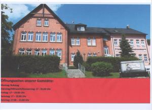 HarraGasthof zum alten Schulmeister的一座大型砖砌建筑,前面有标志