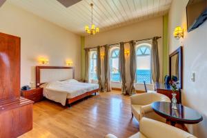 埃尔莫波利斯阿波罗尼奥皇廷酒店的卧室配有一张床和一张桌子及椅子