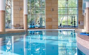 德兹维济诺哈维特Spa度假酒店的蓝色水和窗户的酒店游泳池