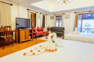 琅勃拉邦Villa Deux Rivieres双河别墅酒店的客房设有带一张床和电视的卧室。