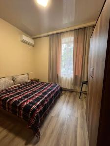 茨卡尔图博Guest House Kolkha的一间卧室设有一张床和一个大窗户