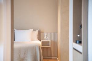 栋堡Hotel Bommelje的一间卧室配有一张带白色床单的床和一台电视。