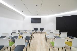 马略卡岛帕尔马JS Palma Plaza的一间设有白色椅子和屏幕的讲座室