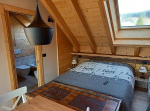 阿夏戈AL SOGNO的小木屋内一间卧室,配有一张床