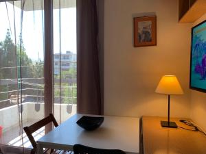 雅典Διαμέρισμα 22 2ου ορόφου στο Χαλάνδρι的配有桌子、灯和窗户的房间