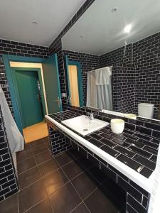 El Encanto de un pueblo mini的浴室设有白色水槽和黑色瓷砖