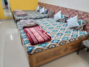 乌贾因Saar Homestay的客房内的两张床和枕头