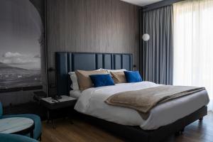 沃拉李奥内莎酒店的一间卧室配有一张带蓝色枕头的大床