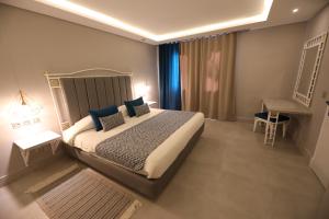 拉马萨Suites Hôtel Les Charmilles & Spa的一间卧室配有一张带蓝色枕头的大床