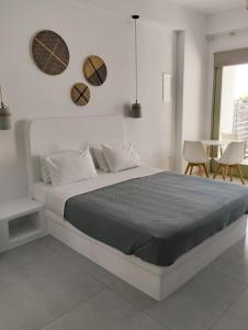提诺斯Allegro suite的白色卧室配有床和桌子
