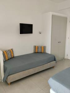 提诺斯Allegro suite的卧室配有一张床铺,墙上配有电视