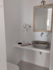 提诺斯Allegro suite的一间带石制水槽和镜子的浴室